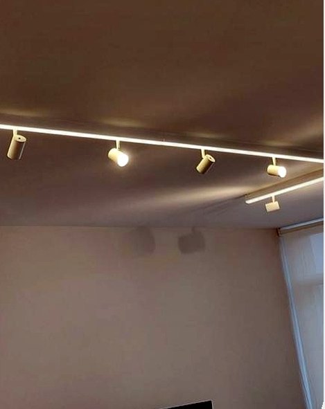 Trilho com spots direcionados e perfil de LED em ambiente comercial iluminado pela MTECH Elétrica