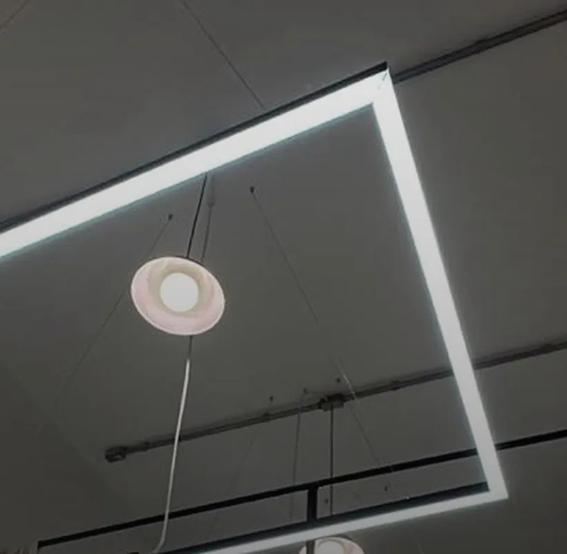 Luminária linear quadrada suspensa por cabos de aço iluminando loja