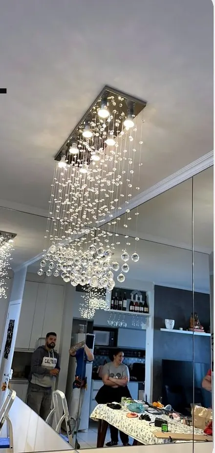 Lustre de cristal instalado sobre mesa de jantar