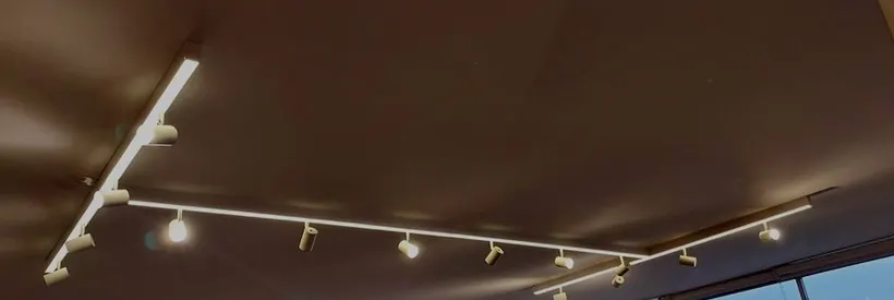 Trilho de iluminação com spots ao longo do teto de sala ampla